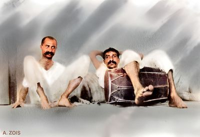 Bombay. Meher Baba with a dholak drum, relaxing with Gustadji.