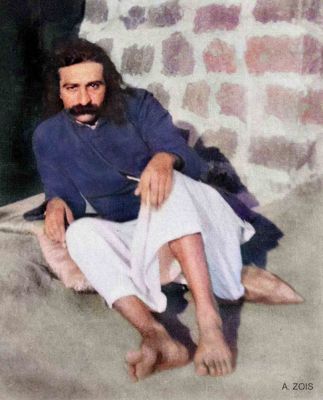 Seated portrait against a brick wall.