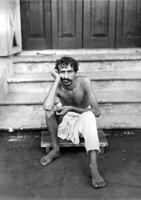 Meher Baba sitting on the steps of Manzil-e-Meem.